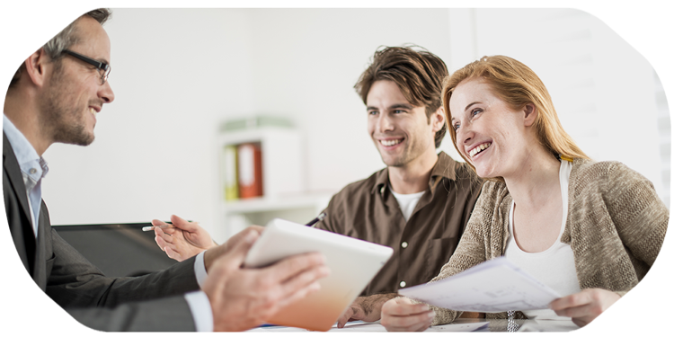 Personen sitzen an einem Tisch und sehen sich Unterlagen an.